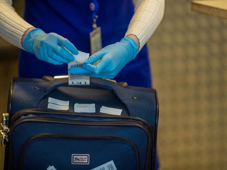 A security officer inspecting a bag at airport screening
